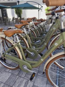eine Reihe grüner Fahrräder nebeneinander geparkt in der Unterkunft Hotel Costa Azzurra in Grado