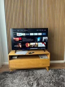 a tv sitting on top of a wooden stand at ModernNest in Ventspils
