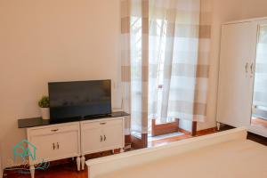 a living room with a flat screen tv on a dresser at Roan Home Pompei 2 in Pompei