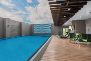 a swimming pool on a building with a wooden deck at Citadines Millennium Ortigas Manila in Manila
