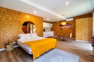 a bedroom with a large bed with a yellow blanket at Penedo Escape Nature in Colares