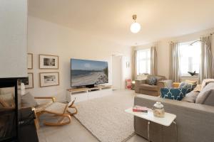 a living room with a couch and a flat screen tv at Fischerhaus in Fehmarn