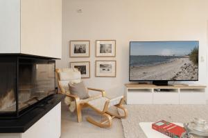 a living room with a tv and a beach at Fischerhaus in Fehmarn +41 photos