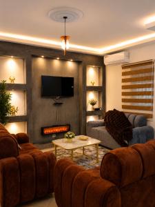 a living room with two couches and a tv at MANDJOU résidence in Abidjan +3 photos