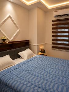 a bedroom with a bed with a blue comforter at MANDJOU résidence in Abidjan