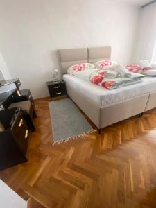 a bedroom with a bed and a wooden floor at Kuća Latice in Tomislavgrad