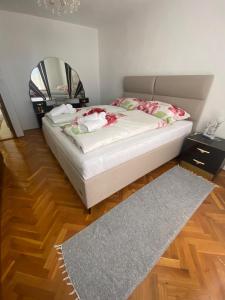 a bedroom with a bed with a mirror and a rug at Kuća Latice in Tomislavgrad