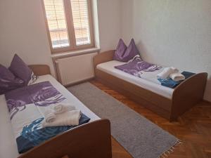 two beds in a small room with towels on them at Kuća Latice in Tomislavgrad