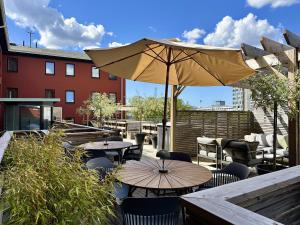 a patio with tables and chairs and an umbrella at Spar Hotel Gårda in Gothenburg