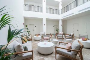 a lobby with chairs and tables and plants at Hotel Estepona Patio in Estepona