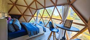 a room with a bed and a table with a laptop at Dôme Diem luxe climatisé in Lesterps