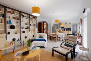 a living room with white furniture and a table at Orotava The Home - Vacational rental with the lifestyle of 1700 and the comfort of 2022 in La Orotava