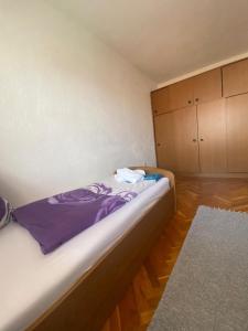 a bedroom with a bed with purple sheets and cabinets at Kuća Latice in Tomislavgrad +17 photos