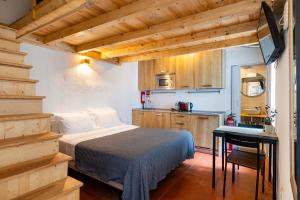 a bedroom with a bed and a table and a kitchen at Penedo Escape Nature in Colares