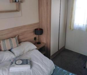 a bedroom with a bed with a pillow and a lamp at Lymington in Leysdown-on-Sea