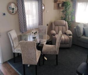 a living room with a glass table and chairs at Lymington in Leysdown-on-Sea