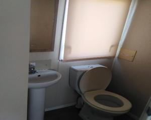 a small bathroom with a toilet and a sink at Lymington in Leysdown-on-Sea
