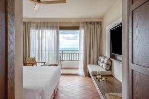 a hotel room with a large bed and a balcony at Creta Maris Resort in Hersonissos
