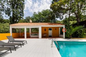 a house with a swimming pool and a patio at Penedo Escape Nature in Colares