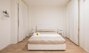 2 posti letto in una stanza bianca con un fiore in cima di Dante 58 a Palermo