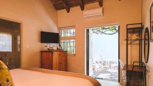 a bedroom with a bed and a sliding glass door at Onse Rus Guesthouse in Prince Albert