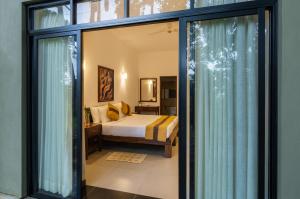 a bedroom with a bed and sliding glass doors at Serenique Resort Kandy in Kandy +47 photos