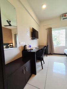 a room with a desk and a bedroom with a bed at IVY RESIDENCY in Trivandrum