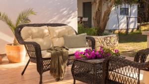 a wicker chair and a couch on a patio at Casa Tramonto I Peaceful Family House with garden, Veli Lošinj in Veli Lošinj