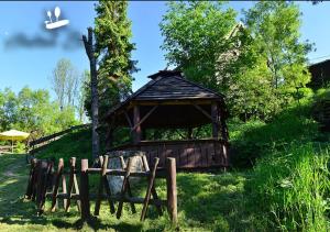 a wooden gazebo in the grass with a fence at Hnatowe Berdo BB in Wetlina