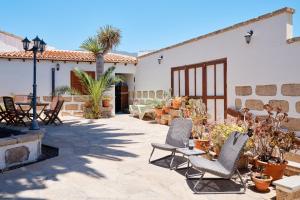 a patio with two chairs and a table with plants at Casa Rural El Traspatio in Granadilla de Abona