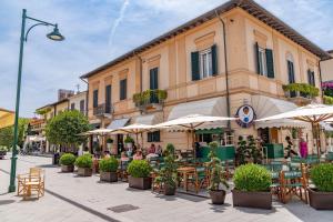 a street with tables and umbrellas in front of a building at Casa Lux Forte dei Marmi in Forte dei Marmi