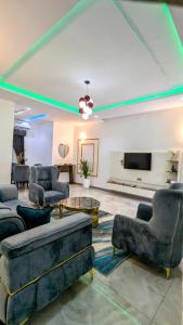 a living room with couches and a flat screen tv at Little Afrika in Port Harcourt