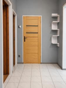an empty hallway with a wooden door and shelves at Mieszkanie Warka in Warka