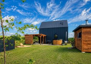 a barn conversion with a patio and a house at Domki Grabina in Grabina