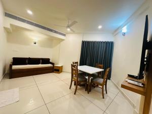 a room with a table and a bed and a table and chairs at KTDC Rain Drops Hotel in Chennai