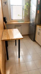 a kitchen with a wooden table and a refrigerator at Mieszkanie Warka in Warka