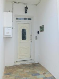 a white door in a white room with a sign at Apartment Kasper in Skiathos