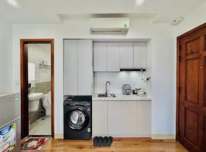 a kitchen with a washing machine in a room at Salux Hotel in Danang