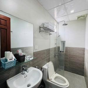 a bathroom with a sink and a toilet and a mirror at Salux Hotel in Danang +34 photos