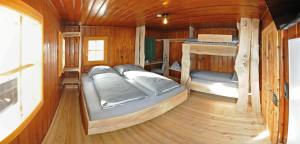 a bedroom with two beds in a wooden cabin at Ferienhof Holzmeister in Sankt Jakob in Haus
