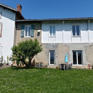 a house with a yard with chairs and an umbrella at Pyrenees Vue Gite Hoopoe - Le Plus Commentaires Positifs,Vues Fantastique, Petit-Déjeuner, Calme, Piscine, Parking in Saint-Gaudens