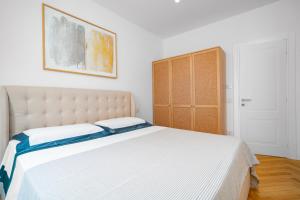 a bedroom with a large bed and a wooden cabinet at Casa Lux Forte dei Marmi in Forte dei Marmi