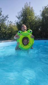 two people in a pool in a swimming pool at Зелена Вілла -басейн,тераса, квіти, сад in Uzhhorod