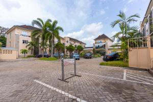 a parking lot with palm trees and some buildings at Amber Residence GRA Ikeja in Ikeja