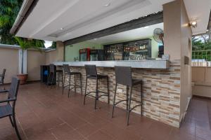 a bar with stools in front of a brick wall at Amber Residence GRA Ikeja in Ikeja