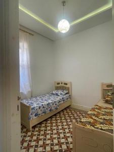 a bedroom with two beds and a checkered floor at blue house in Carthage