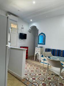 a living room with a table and a refrigerator at blue house in Carthage