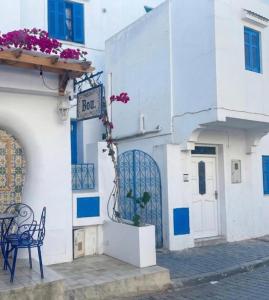 a white building with a table and a sign on it at blue house in Carthage