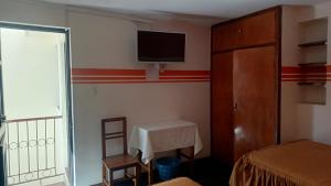 a room with a bed and a tv on the wall at Hostal Churuquella in Sucre +4 photos