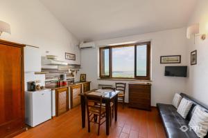 a living room with a table and a kitchen with a couch at PoloTuristicoUmbria Rustico con Piscina Vista Lago in Passignano sul Trasimeno